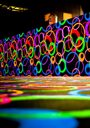 A vibrant wall and floor decorated with colorful overlapping circles, creating a lively, abstract pattern in bright neon hues.