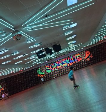 A skateboarder rides down a long, empty hallway, showcasing their skills and balance on the board.