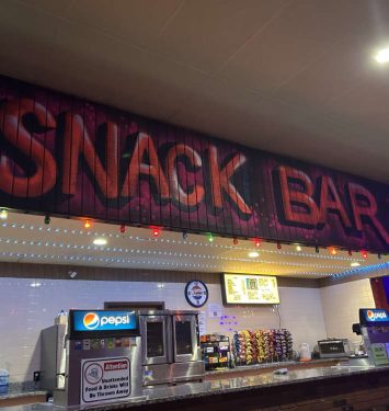 Snack bar sign displayed prominently in front of a restaurant, indicating a place for quick food and refreshments.