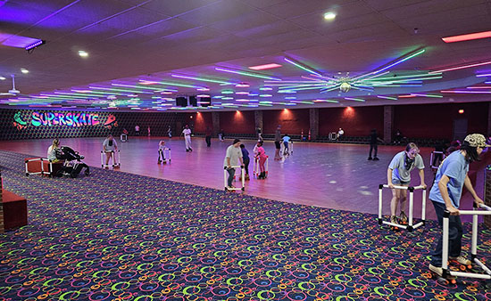 A spacious room filled with people skating on a smooth floor, enjoying the activity and socializing with one another.